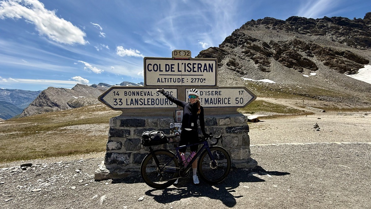 Ramona Furter with her road bike at the Col de l'Iseran summit sign, 2770 metres